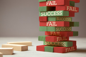 Success and fail. Wooden tower of blocks. Failure is like a new step for success. Failure gives...