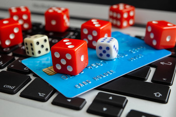 Gambling online. Playing dices and  credit card on laptop keyboard. Gaming addiction