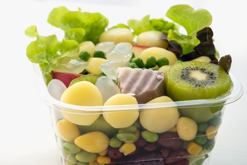 Salad of fresh vegetables and healthy grains ,In clear plastic box,On a white background