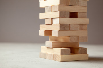 Tower of wooden blocks on gray background. Board game for the whole family or party. Concept of...