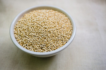 Quinoa in white cup. Raw white quinoa