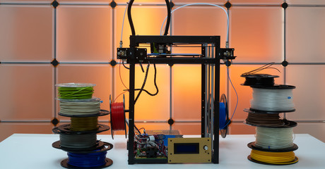 3d printer and plastic filament on color background