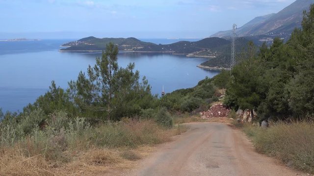 4K Zoom out country road downhill to the sea