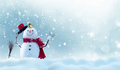 Naklejka na ściany i meble Merry christmas and happy new year greeting card with copy-space.Happy snowman standing in winter christmas landscape.Snow background