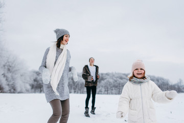 Happy family. Mother and child daughters on a winter walk outdoors. 