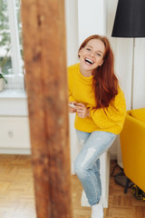 Laughing playful young woman indoors at home