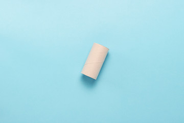 Empty roller from toilet paper on a blue background. Flat lay, top view