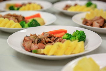 Steak pork sliced cube with vegetables such as tomatoes, carrot, broccoli and pineapple.