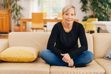 Fototapeta premium Cross-legged woman relaxing on a couch