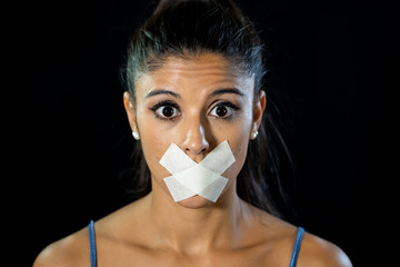 Attractive frightened young woman mouth sealed on adhesive tape