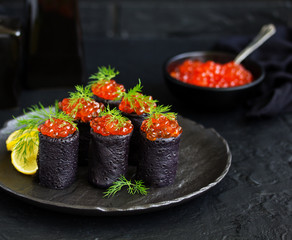 Pancakes with cuttlefish ink with red caviar. Russian kitchen.