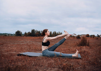 Fototapeta na wymiar Athletic girl doing stretching on the mat