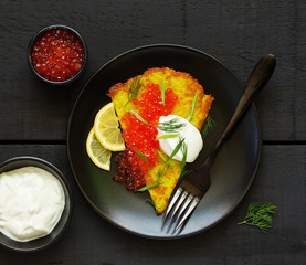 Potato rusty (potato pancake) with red caviar. View from above.