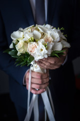 Wedding bouquet in the hands of the groom