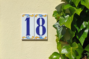 Casa con un azulejo del número 18 en la fachada de la calle, Andalucía, España