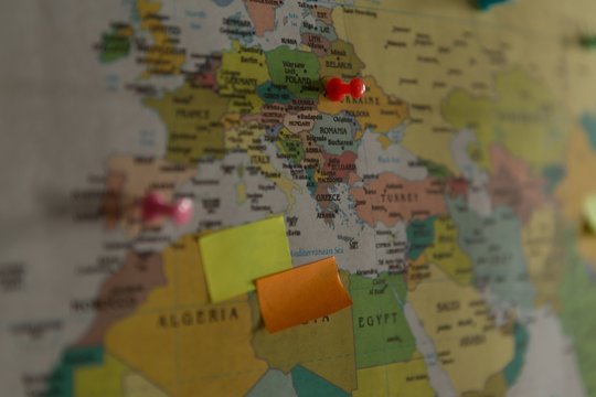 Sticky notes and board pin attached on world map
