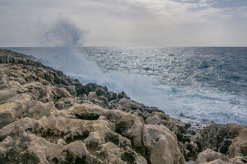 Sea waves splashing on cliffs, marine background