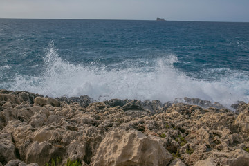 Sea waves splashing on rocky shore, marine background	