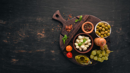 Cherry mozzarella cheese. Top view. On a black wooden background. Free copy space.