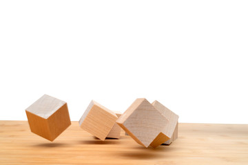 Wooden cubes roll on an inclined plane.