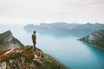 Poster Active man traveling walking alone on cliff mountain edge above sea adventure healthy lifestyle summer vacations outdoor in Norway solitude emotions © EVERST