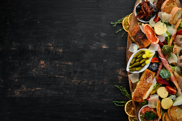 A set of food. Snacks of Italian cuisine. On a wooden background. Top view. Free copy space - obrazy, fototapety, plakaty