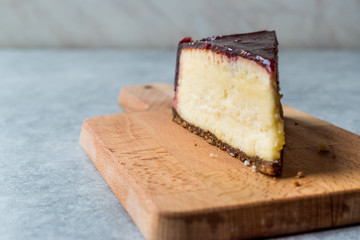 Raspberry Cheesecake Slice on Wooden Board with Paper.