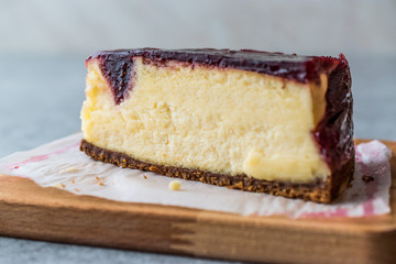 Raspberry Cheesecake Slice on Wooden Board with Paper.