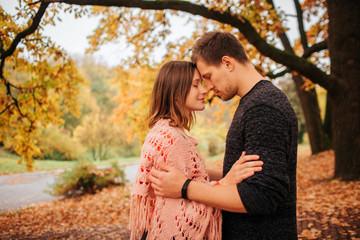 Fototapeta premium Calm and peaceful picture of couple leaning to one another. They keep their foreheads together. Couple is in park.