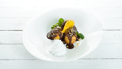 Pastry with chocolate and cream. On a wooden background. Top view. Free copy space.