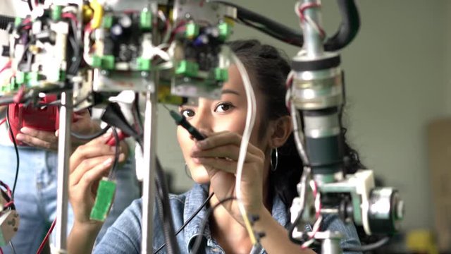 Engineer female collaborating development robot in modern laboratory. concept of hardware technology, robotic engineering, artificial intelligence and automation control. 4K Resolution.