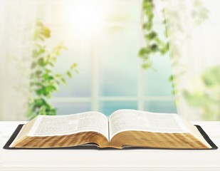 Open book on old wooden table.