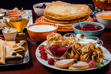 Shrovetide Maslenitsa festival meal. Russian pancakes blini with honey, fresh cream cheese and red caviar. Rustic style