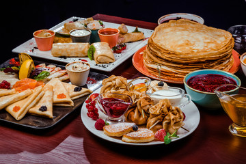 Shrovetide Maslenitsa festival meal. Russian pancakes blini with honey, fresh cream cheese and red...