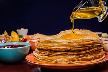 Shrovetide Maslenitsa festival meal. Russian pancakes blini with honey, fresh cream cheese and red...