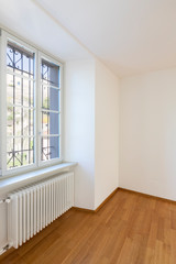 Empty room with parquet and window overlooking the castle