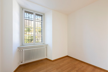 Empty room with parquet and window overlooking the castle