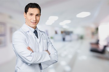 Young smiling doctor portrait on blurred hospital background