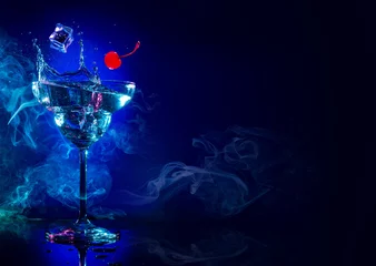 Crédence de cuisine en verre imprimé Cocktail glace et cerise tombant dans un cocktail splash sur fond bleu fumé