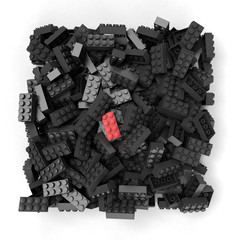 Red plastic brick contrasting on black ones