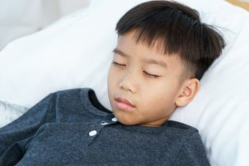 Young boy sleep on a white bed