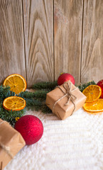 New Year's table with tangerines or oranges on a wooden table with branches of a Christmas tree and New Year's gifts.
