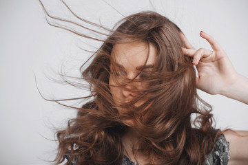 Portrait of girl with developing hair, on a grey background. No face