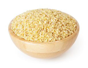 Uncooked bulgur in wooden bowl isolated on white background with clipping path