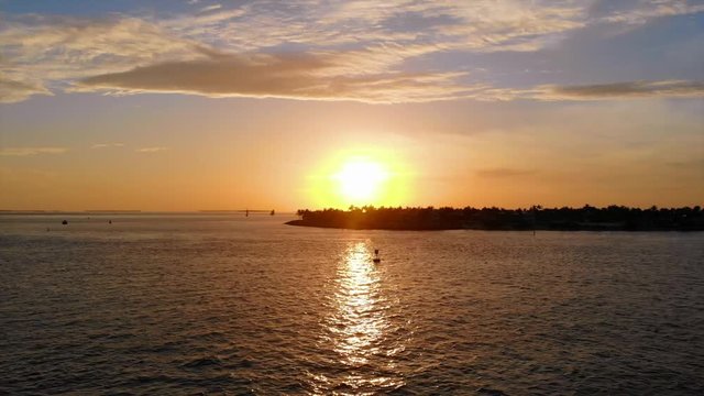 KEY WEST, FL, USA - APRIL 23, 2018: Aerial drone footage made over the ocean to Mallory Square during sunset in Key West