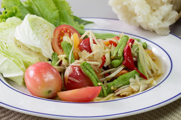 Green papaya Salad (Som Tum Thai) and sticky rice in bamboo container, Thai food