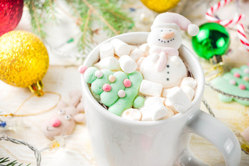 Obraz na płótnie Canvas Creative idea for christmas drink, delicious hot chocolate with funny marshmallow snowman, christmas tree, rain dear, santa, on home background with xmas decoration copy space top view