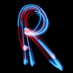 Letter R of the alphabet made from neon sign. The blue light image, long exposure with colored fairy lights, against a black background