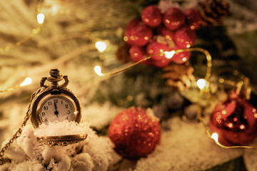 Vintage New year clock and cones covered with snow