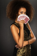 Young afro woman holding playing cards